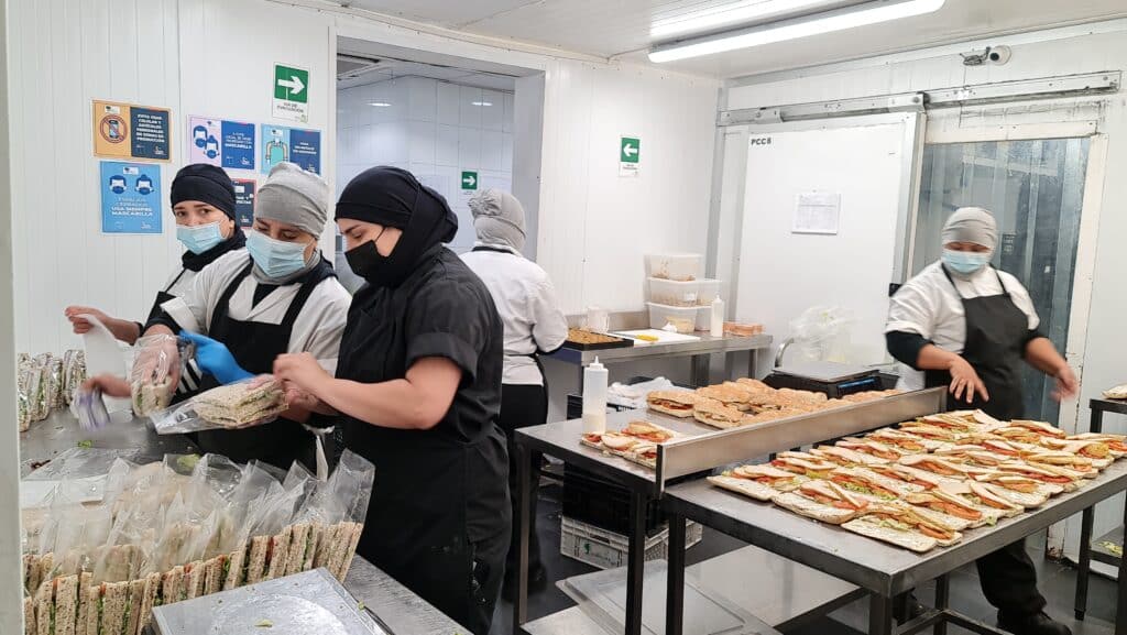 Personas trabajando en la industria de alimentos preparados.